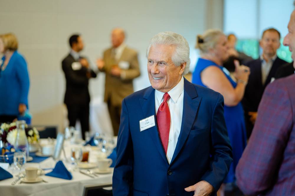 Guest standing and smiling at the Foundation Annual Meeting